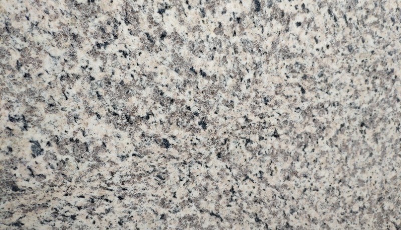 Tiger Skin White granite slab, cream base with grey and black spots