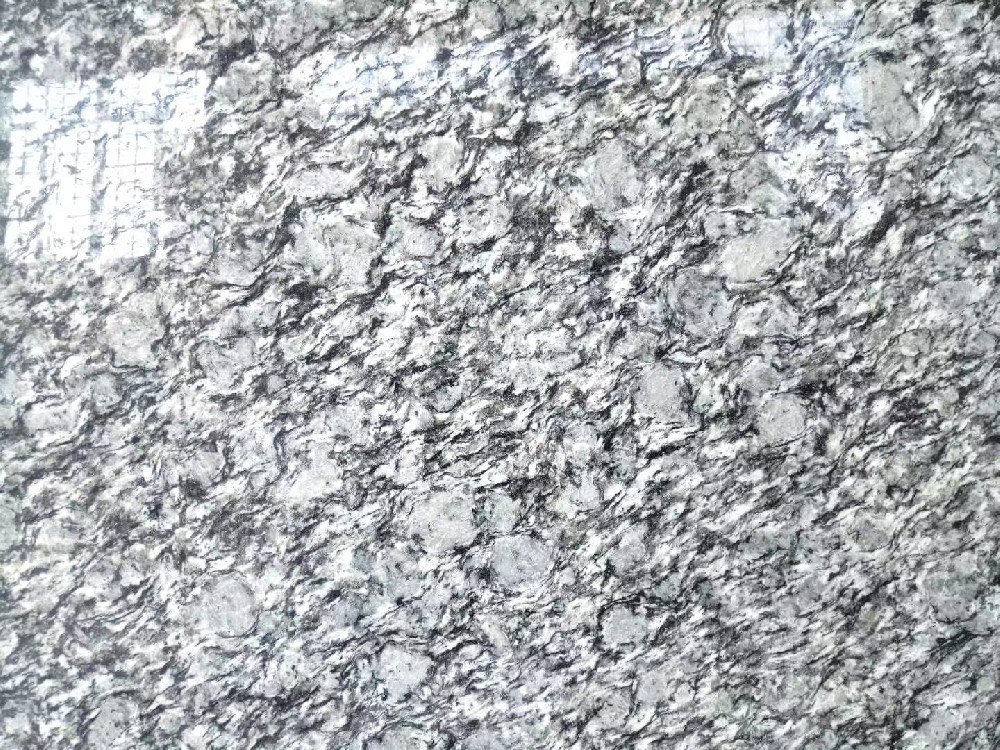 Wave White granite slab with flowing grey and black streaks